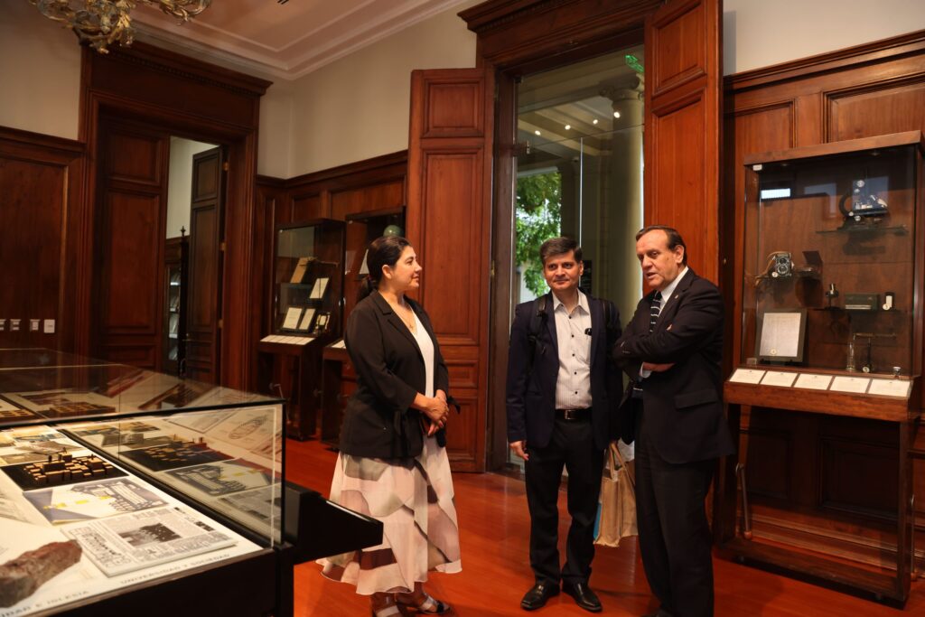 tres personas conversando en un museo con exhibiciones detrás