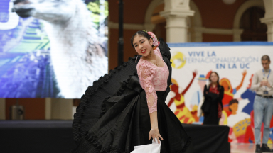 Actuación de danza folklórica en un evento cultural con fondo colorido