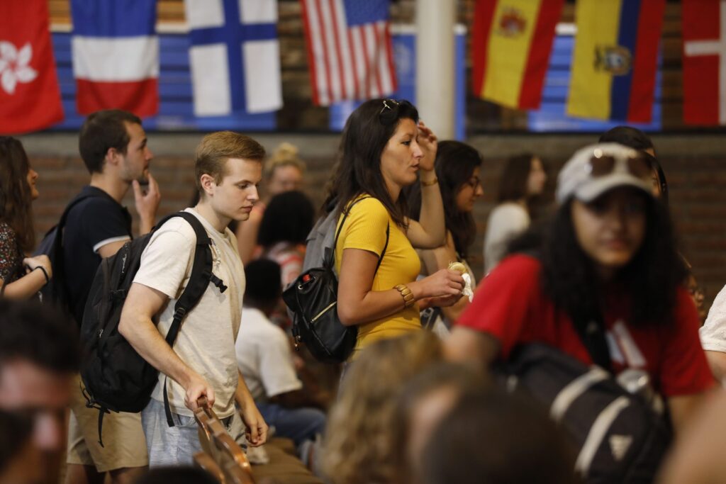 Grupo de estudiantes participando en un evento multicultural con banderas de varios países.