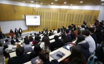 Estudiantes presentando un proyecto de innovación frente a una audiencia dentro de una sala de clases.